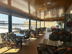 a restaurant with tables and chairs and a large window at NUS GRAND HOTEL in Çatalözü
