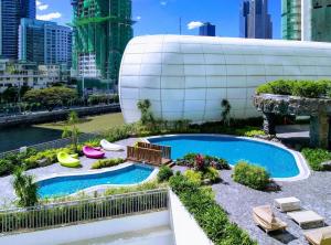 a swimming pool in the middle of a city at Luxxe interior design condo @ Novotel Suites Manila - Acqua in Manila