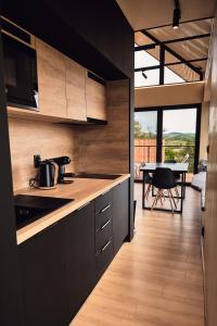 a kitchen with black cabinets and a table with a dining room at Chata Scheelit in Banská Štiavnica