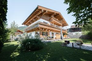 a log house with a large roof at Bewegte Berge Apartments in Saalfelden am Steinernen Meer
