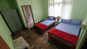 een slaapkamer met 2 bedden en een spiegel bij Mountain View Passaddhi Comfort Stay in Kalimpong