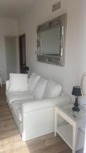 um sofá branco numa sala de estar com um espelho em Maison Valentina em Marendole