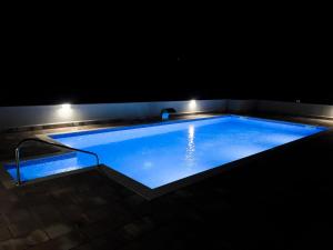 a large swimming pool at night with lights at Villa Ellie in Ljubuški