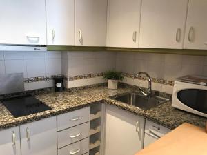 a kitchen with white cabinets and a sink at Appartement à MALAGA in Málaga