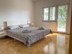 a white bedroom with a bed with a blanket at Villa Ellie in Ljubuški