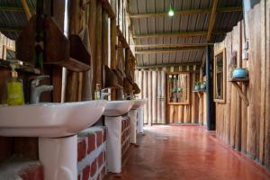 a bathroom with three sinks in a barn at Kalitusi Nature Resort in Fort Portal