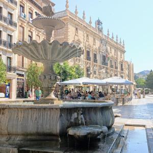 a fountain in the middle of a street with a building at Donde Antonio in Granada