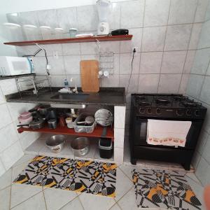 a kitchen with a stove and a counter top at Casa temporada Guriri in São Mateus