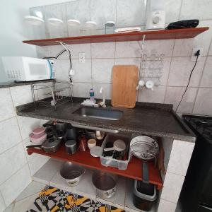 a kitchen counter with a sink and some pots and pans at Casa temporada Guriri in São Mateus +20 photos