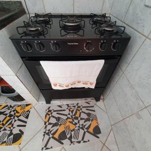 a black stove in a kitchen with a tile floor at Casa temporada Guriri in São Mateus