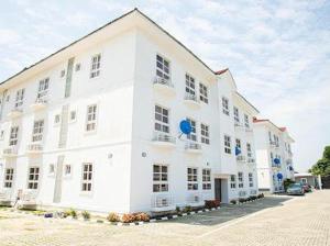 a large white building with a lot of windows at Novara Apartments in Lekki