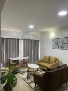 ein Wohnzimmer mit einem Sofa und einem Tisch in der Unterkunft Novara Apartments in Lekki