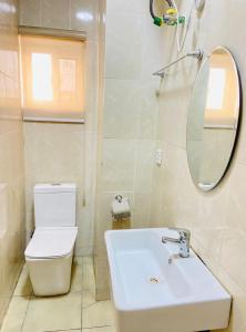 a bathroom with a toilet and a sink and a mirror at Novara Apartments in Lekki