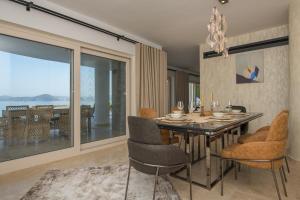 een eetkamer met een tafel en stoelen met uitzicht bij Bodrum'da Denize Sıfır Muhteşem Villa Boss 2 in Milas
