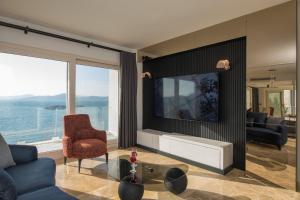 een woonkamer met een blauwe bank en een tv bij Bodrum'da Denize Sıfır Muhteşem Villa Boss 2 in Milas