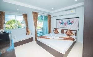 ein Schlafzimmer mit einem großen Bett und einem Fenster in der Unterkunft Happy 99 Guest house in Patong Beach