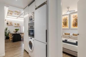 een keuken en een woonkamer met een wasmachine en droger bij BNBHolder Plaza de Oriente es MIA in Madrid