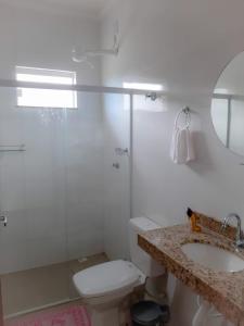 ein Bad mit einer Dusche, einem WC und einem Waschbecken in der Unterkunft 2 suítes c/ Ar, Piscina, Churrasqueira, 500mt Mar in Santa Cruz Cabrália