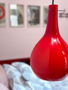 a red glass vase hanging over a bed at Ninù Roma centro storico in Rome