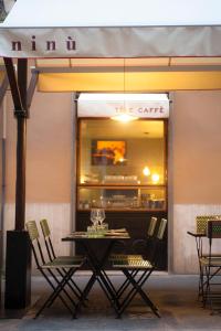 une table et des chaises devant un café dans l'établissement Ninù Roma centro storico, à Rome