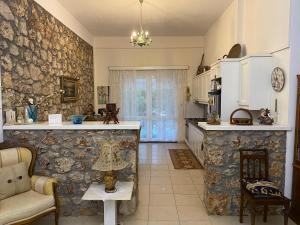 Linariá的住宿－THE MANSION OF DIONISOS AND DIMITRAS，厨房设有石墙、柜台和椅子