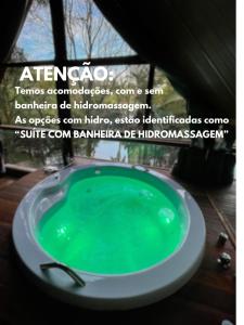 a green bath tub sitting in a bathroom at Pousada Vale das Orquídeas in Lavrinhas
