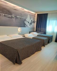 a hotel room with two beds and a painting on the wall at The Sydney Hotel in Bologna