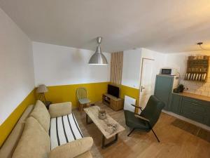 a living room with a couch and a kitchen at Joli logement au calme in Vésonne