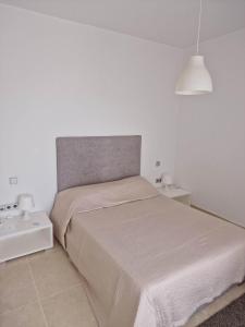 a white bedroom with a bed and a lamp at CityCosy Super Moderne, Confortable, Spacieux et Calme in La Marsa