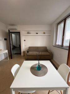 un soggiorno con un tavolo bianco e un divano di casa manuel a Gallarate