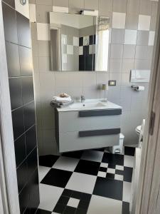une salle de bain avec un lavabo et un sol à carreaux noirs et blancs dans l'établissement Canovine 13, à Bergame 18 autres photos
