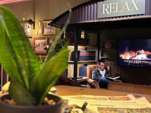 a man sitting at a table reading a book at Privathotel Riesenbeck in Riesenbeck