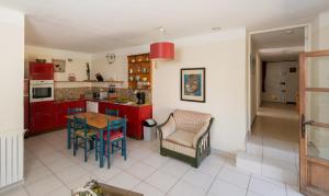 SabranにあるLe Fer en Cèzeのキッチン(赤いキャビネット、テーブル、椅子付)