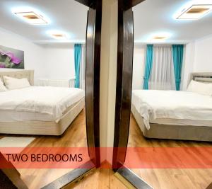 two beds in a room with a mirror at Royal Grand Suite in Cluj-Napoca