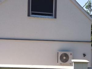 a white building with a window and a fan at Apartman for You in Gyenesdiás