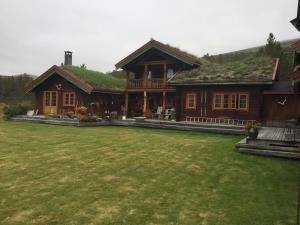 a large house with a grassy yard in front of it at Øvre Nordli Rondane Utleie Sollia Friluftsliv in Sollia