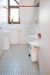 een witte badkamer met 2 wastafels en een toilet bij Maisonette-Wohnung Airport/Messe Stuttgart - Balkon - Parkplatz - Netflix in Filderstadt