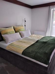 Un dormitorio con una cama grande con una manta verde. en Ferienwohnung Familie Cischeck en Gauting