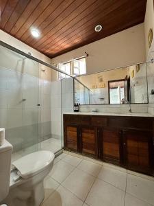 a bathroom with a toilet and a shower and a mirror at Pousada Morena in Morro de São Paulo