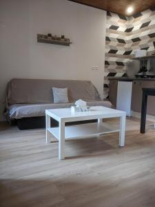 a white coffee table in a living room with a couch at Appartement et salle de jeu in Saint-Claude