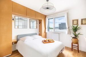 a bedroom with a white bed with a tray of food on it at LA BELLE ROSE - Appartement 4 personnes proche gare Bordeaux in Bègles