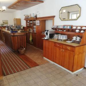 une grande cuisine avec des placards en bois et un miroir dans l'établissement Alpengasthof Gutenbrunn, à Mallnitz