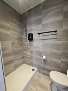 a bathroom with a shower and a toilet at Self contained studio flat in Luton -Close to luton airport - Luton Dunstable Hospital - Business contractors - Family - All welcome -Short or Long Stay in Luton