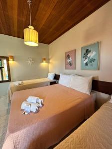 a bedroom with two beds with towels on them at Pousada Morena in Morro de São Paulo
