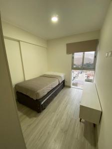 a bedroom with a bed and a large window at Dpto con hermosa vista al hipódromo de Monterrico in Lima