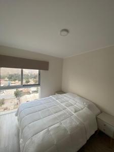 a bedroom with a white bed and a large window at Dpto con hermosa vista al hipódromo de Monterrico in Lima