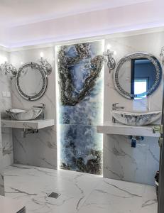 Baño con 2 lavabos y espejos en la pared en PIOTROWSKI APARTMENTS, en Theológos