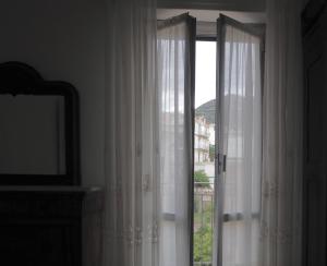 a window with white curtains in a room at Casa Vintage in Alassio