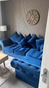 a blue couch with blue pillows in a living room at holiday apartment in Ardrossan