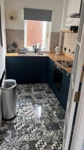 a kitchen with a black and white tile floor at holiday apartment in Ardrossan